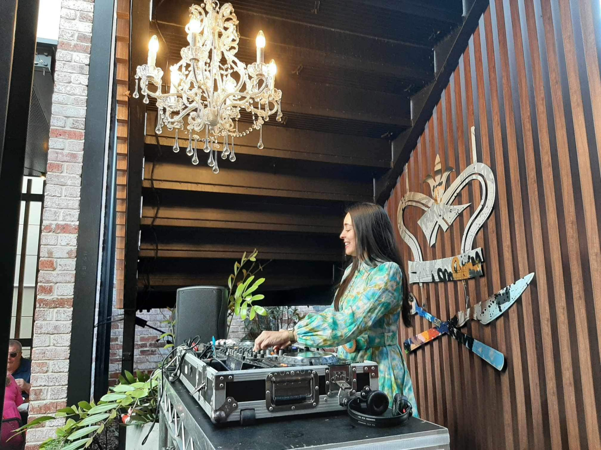 JoNisha DJing beneath a crystal chandelier at a Perth venue