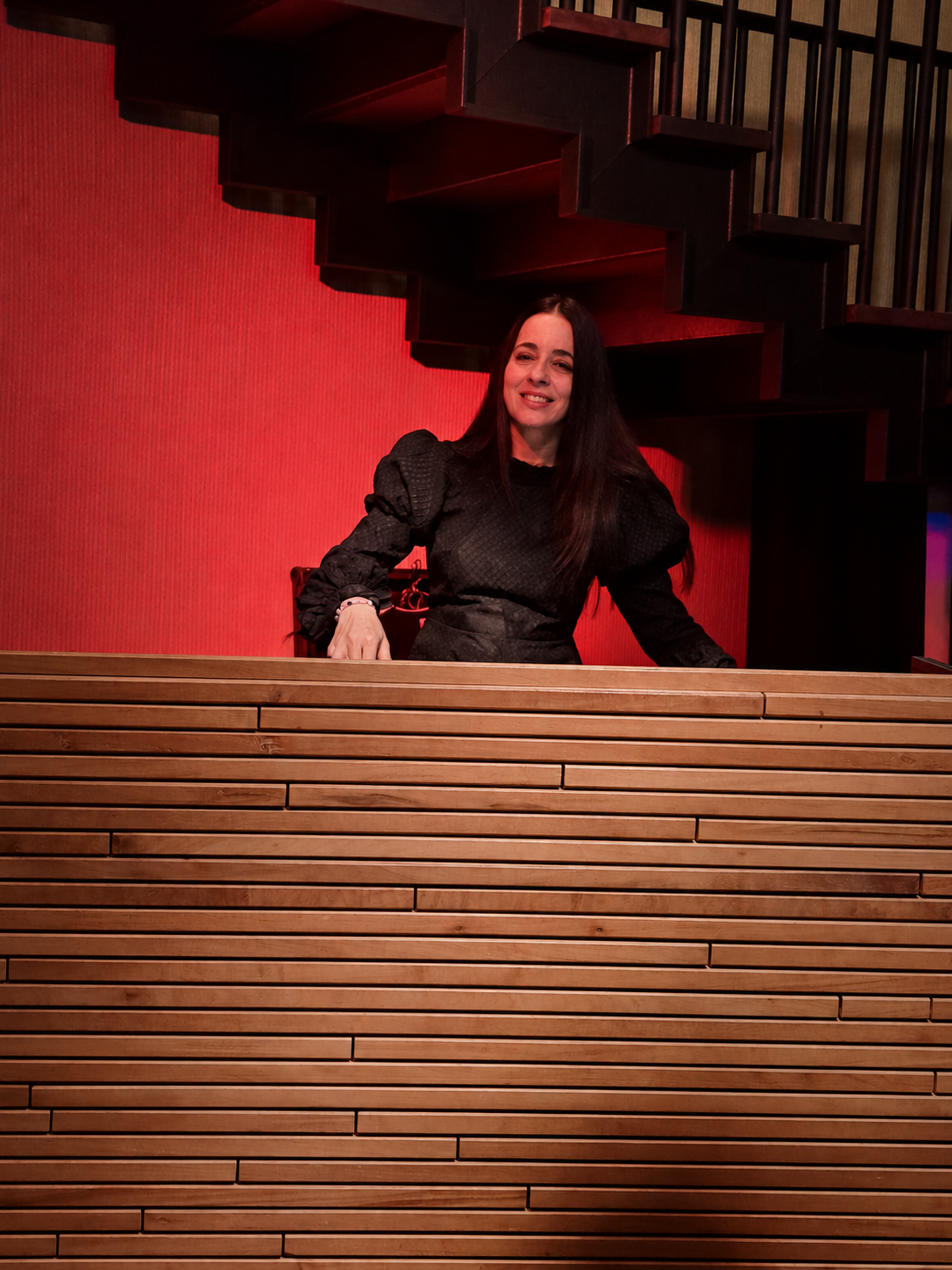 JoNisha in a black outfit inside a red-lit Perth venue
